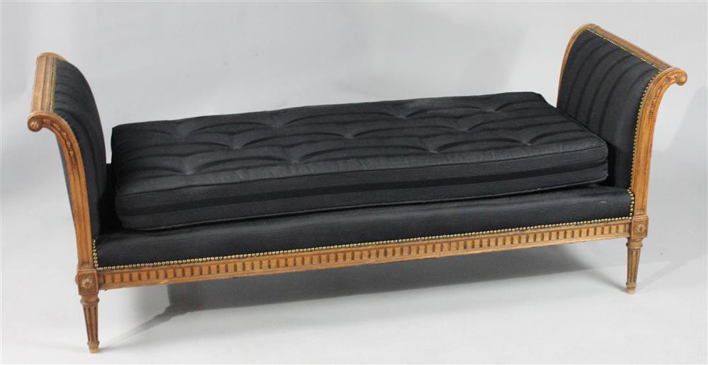 Appraisal: LOUIS XVI STYLE FRUITWOOD BLACK TUFTED DAYBED carved outscrolling arms