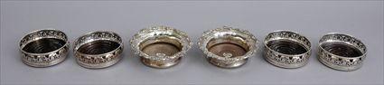 Appraisal: SET OF FOUR ENGLISH SILVER-PLATED BOTTLE COASTERS AND A PAIR