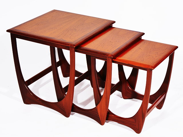 Appraisal: A NEST OF THREE TEAK G-PLAN TYPE TABLES with shaped