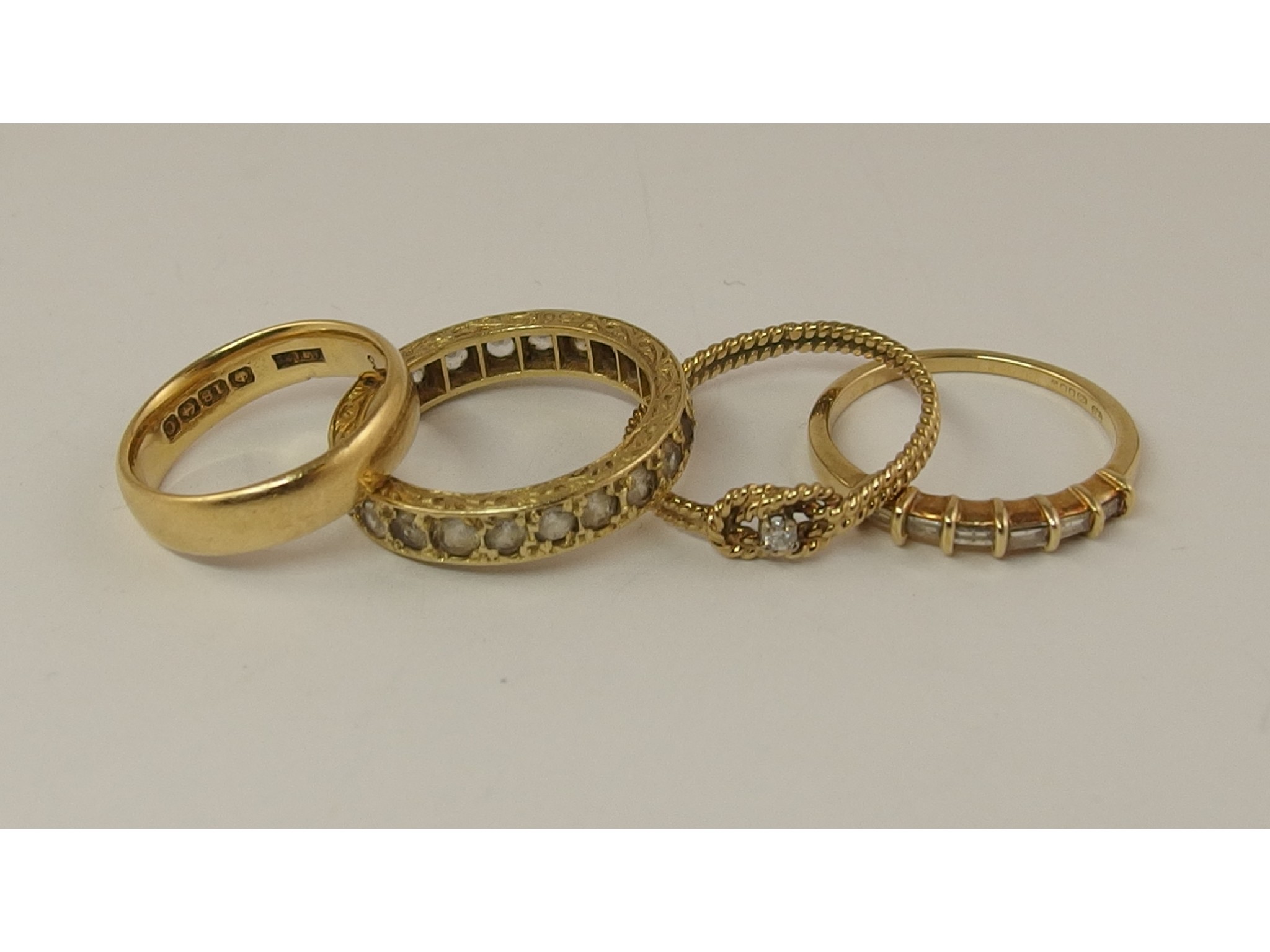 Appraisal: An ct wedding band and three gold and yellow metal