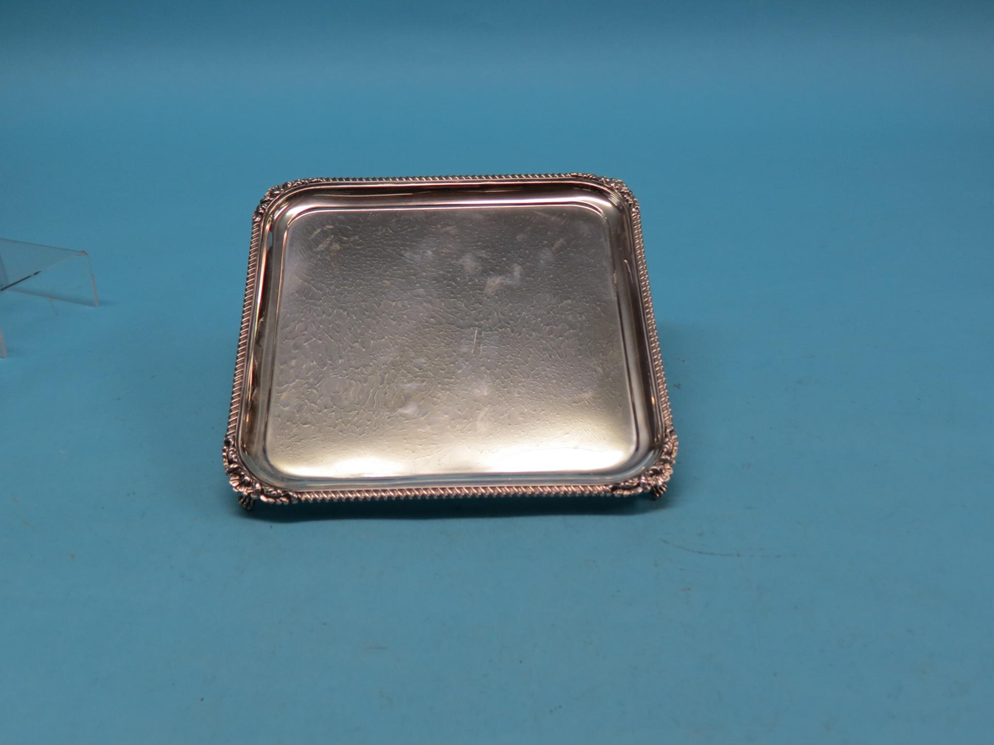 Appraisal: A silver salver square-shape with cast gadrooned rim on claw