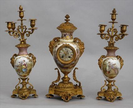 Appraisal: LOUIS XVI-STYLE THREE-PIECE GILT-METAL MOUNTED PORCELAIN CLOCK GARNITURE The ovoid