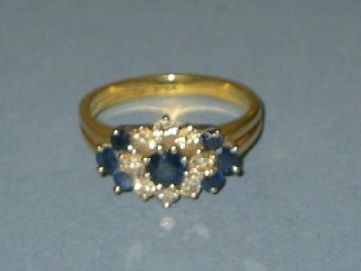 Appraisal: A SAPPHIRE AND DIAMOND CLUSTER RING the central sapphire claw