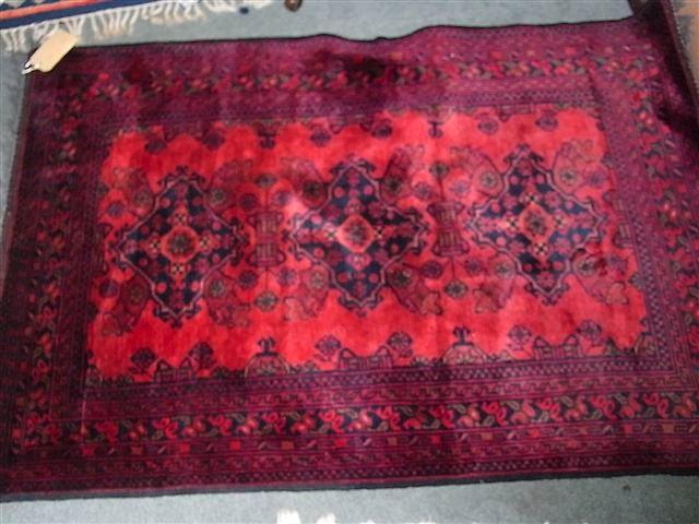 Appraisal: A TURKISH RED GROUND RUG with traditional medallions within a