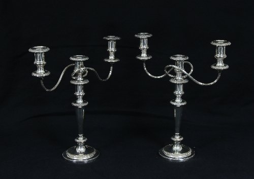 Appraisal: A pair of plated two-branch three-light candelabra with scroll branches