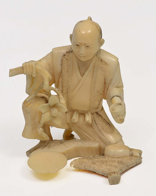 Appraisal: A JAPANESE IVORY OKIMONO of a seated gardener signed to