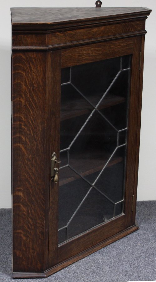 Appraisal: An oak corner cupboard enclosed by a glazed leaded bar