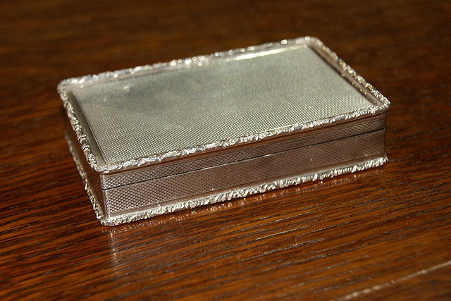 Appraisal: Silver snuff boxof rectangular form with engine turned decoration relief