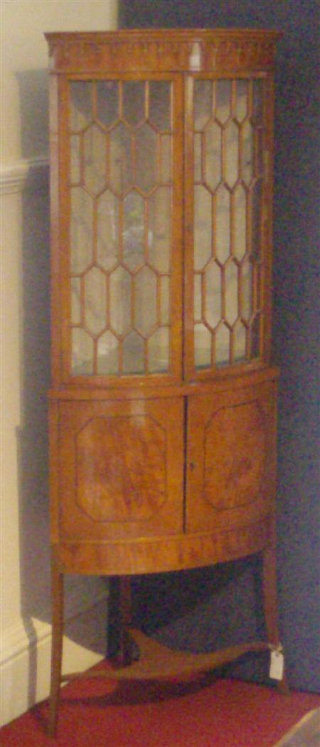 Appraisal: An Edwardian satinwood bowfront standing corner display cabinet the pair