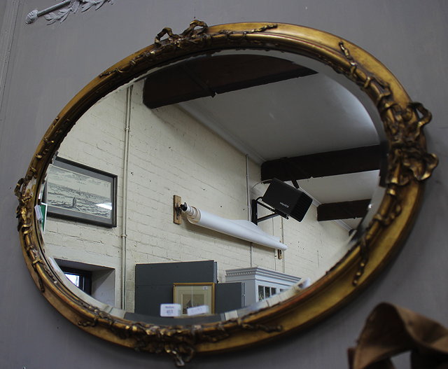 Appraisal: A TH CENTURY GILT FRAMED OVAL WALL MIRROR with ribbon