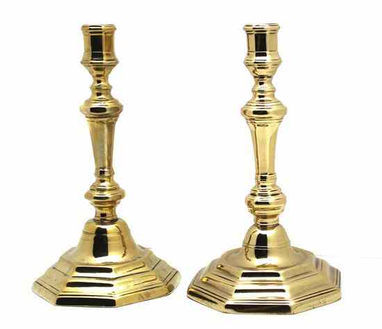 Appraisal: A Pair of Brass Candlesticks each raised on an octagonal