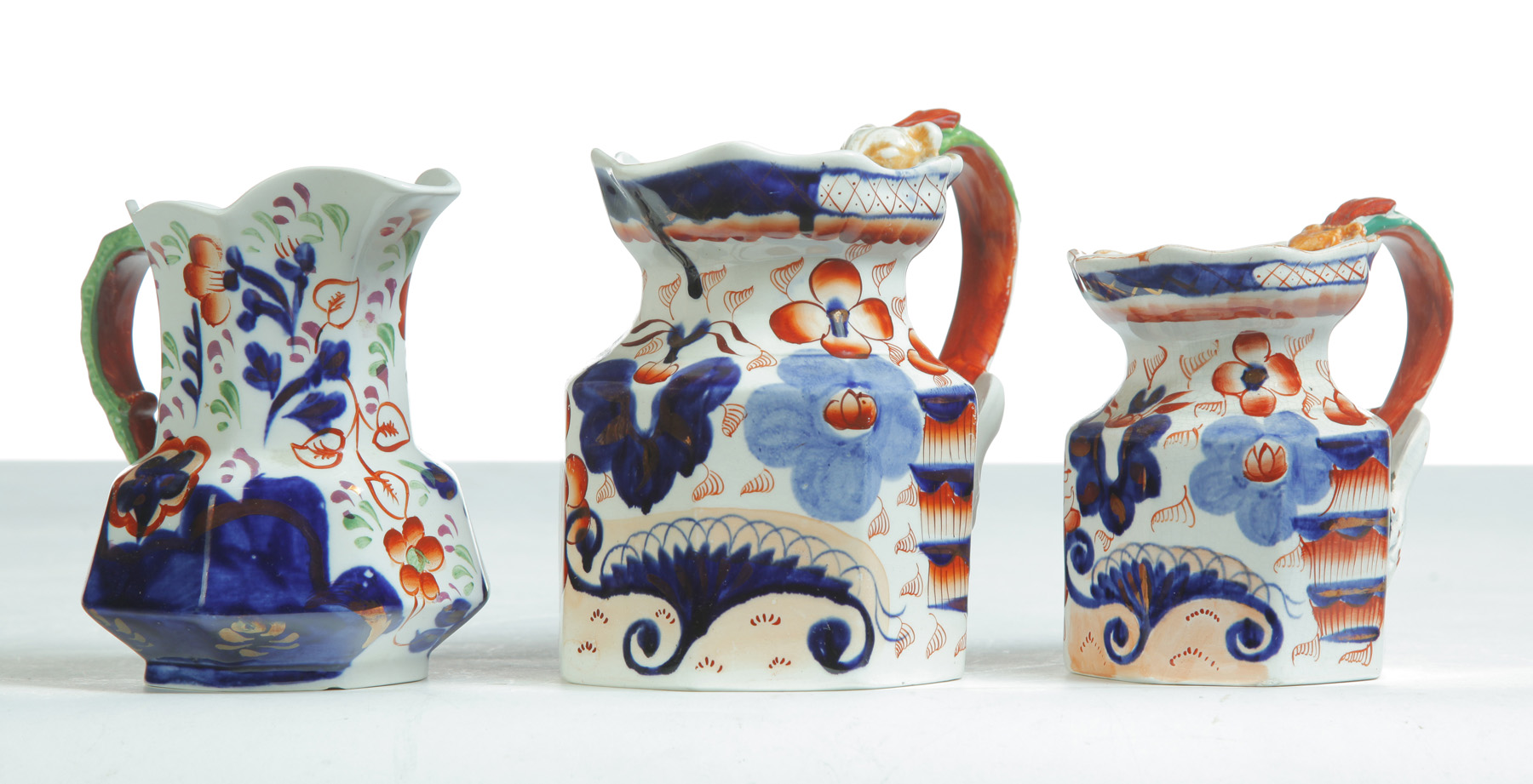 Appraisal: THREE IRONSTONE CREAMERS WITH IMARI DECORATION England mid th century