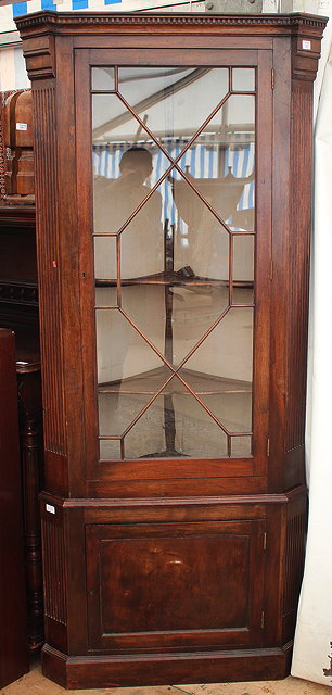 Appraisal: A GEORGIAN STYLE MAHOGANY FLOOR STANDING CORNER CUPBOARD with astragal