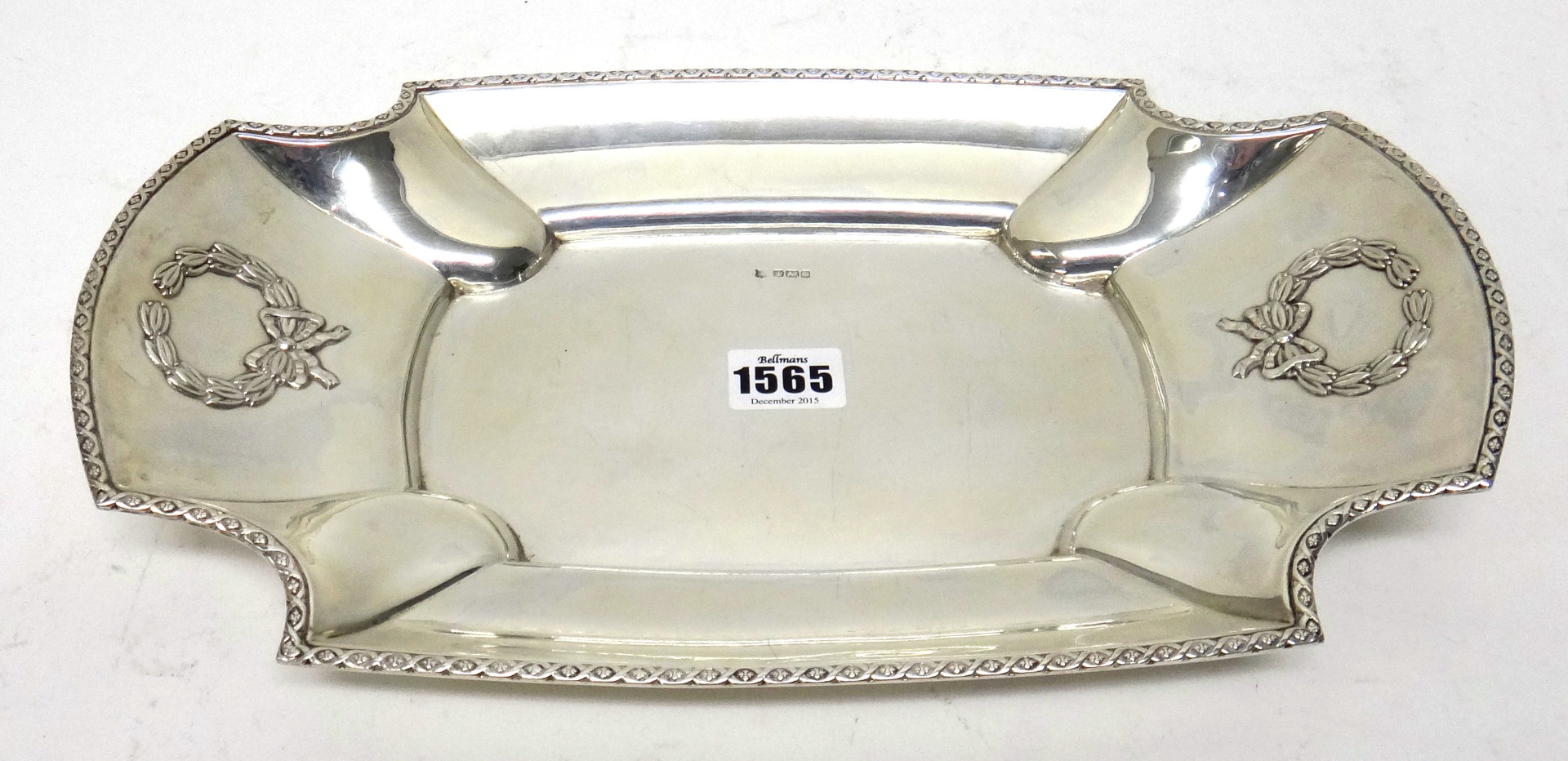 Appraisal: A silver shaped rectangular bread dish decorated with two wreaths