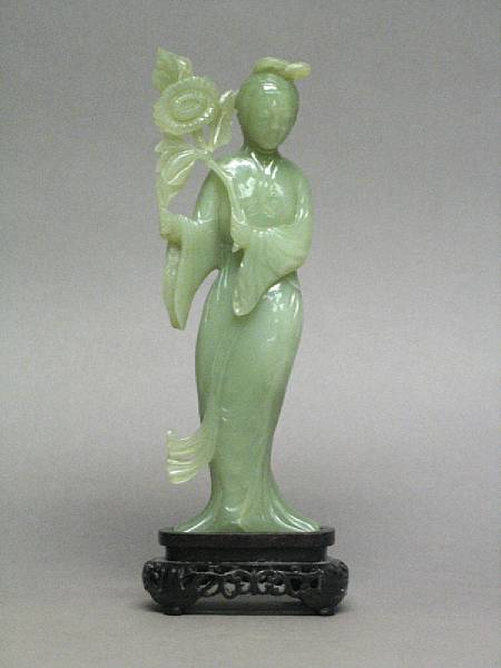 Appraisal: A carved green hardstone figure of beauty holding a flower