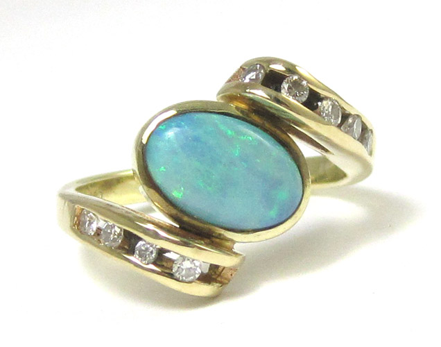 Appraisal: OPAL DIAMOND AND FOURTEEN KARAT GOLD RING the crossover style