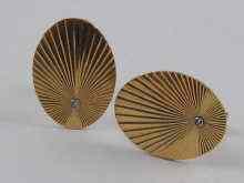 Appraisal: A pair of oval cufflinks with sunburst decoration and set