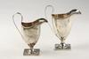 Appraisal: CREAMERS - Two English hallmarked helmet form creamers with strap