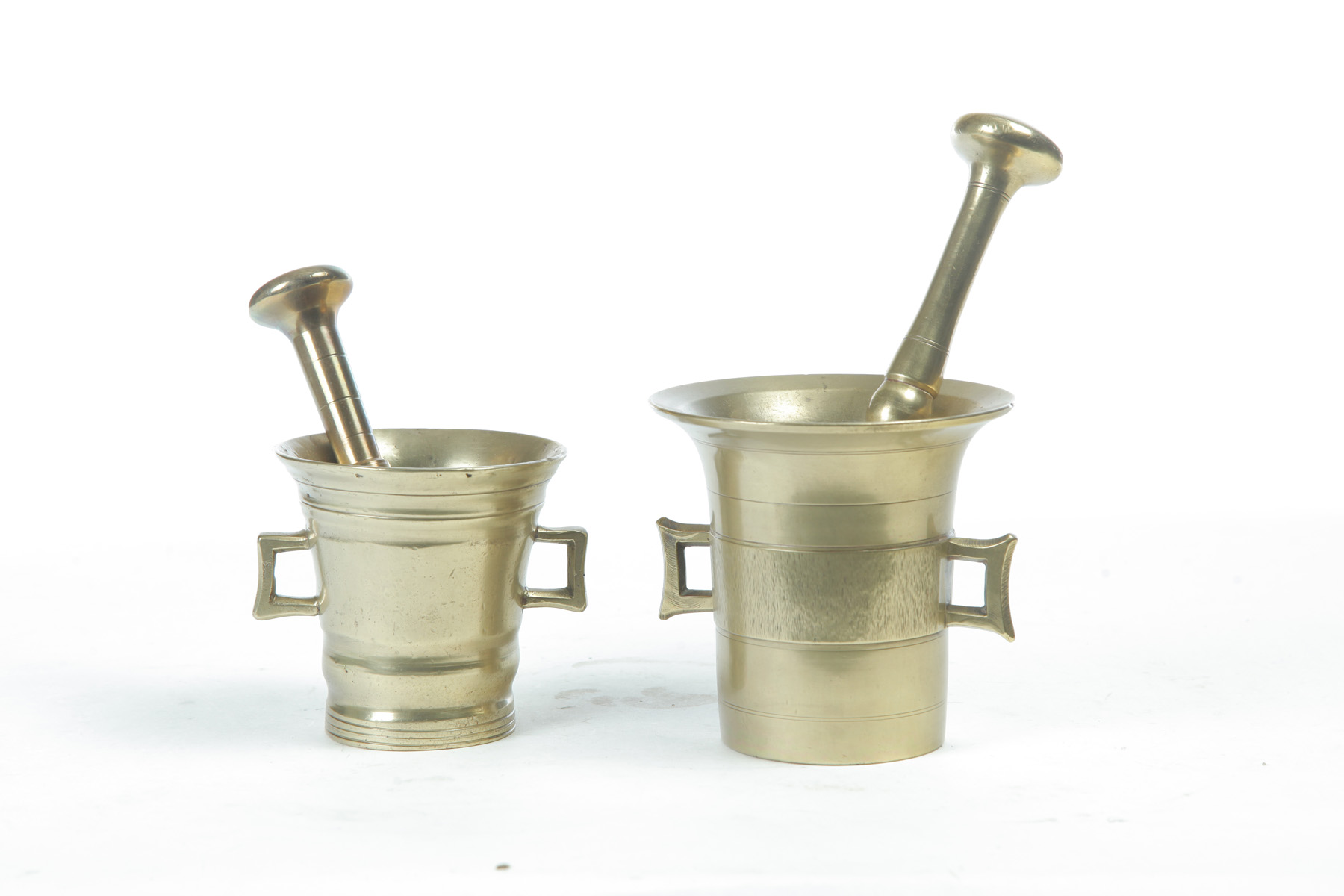 Appraisal: TWO EUROPEAN BRASS MORTARS AND PESTLES Nineteenth century Flared rims