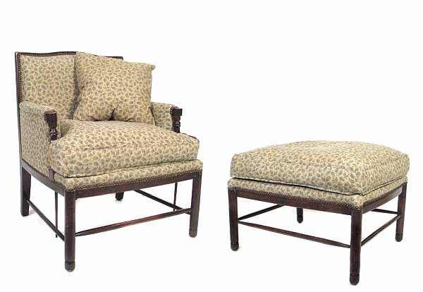 Appraisal: A fully upholstered armchair and matching ottoman on turned legs