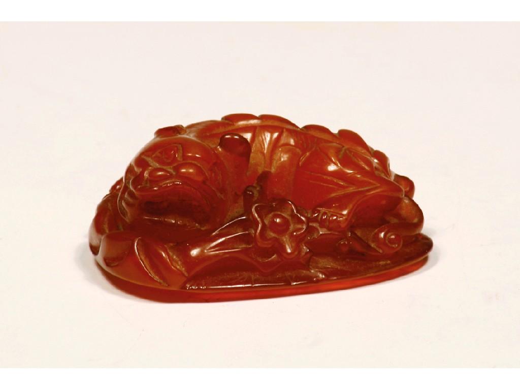 Appraisal: A CHINESE CARVED AMBER PENDANT relief carved as a mythical