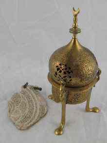 Appraisal: An Islamic brass incense burner together with a shell pendant