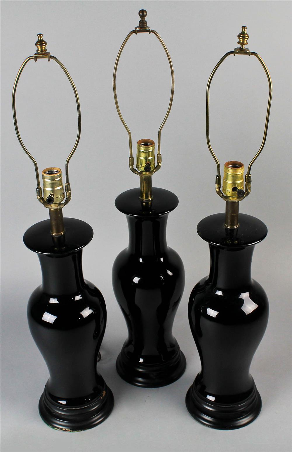 Appraisal: THREE BLACK BALUSTER TABLE LAMPS on circular wood bases electrified