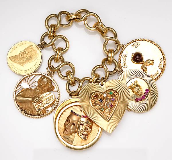 Appraisal: A fourteen karat gold charm bracelet suspending seven charms including