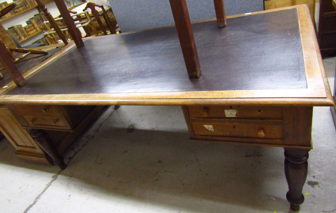 Appraisal: An early thC oak desk with a one-piece black leatherette