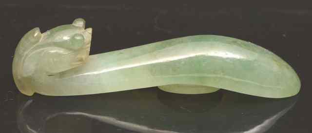 Appraisal: A TRANSLUCENT GREEN JADE BUCKLE with stylised dragon head hook