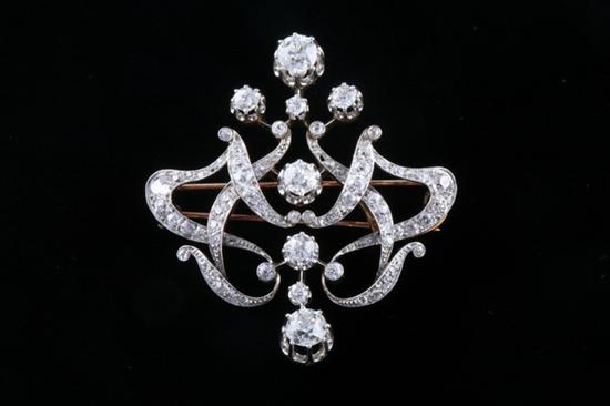 Appraisal: EDWARDIAN ART NOUVEAU-INFLUENCED PLATINUM-ON-YELLOW-GOLD AND DIAMOND BROOCH Six old mine