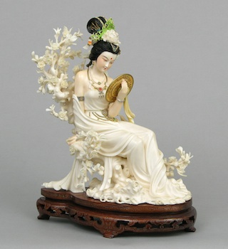 Appraisal: A Carved Ivory Seated Woman A carved ivory or bone