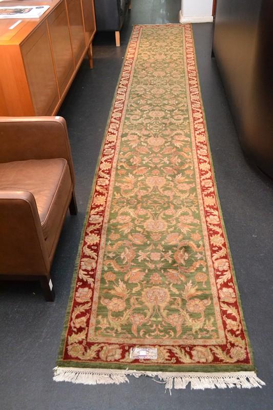 Appraisal: A PERSIAN RUNNER IN GREEN AND BURGUNDY TONES A PERSIAN