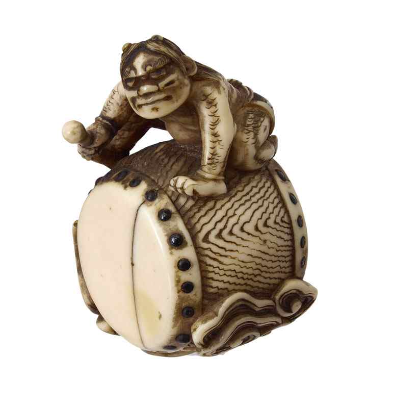 Appraisal: CARVED IVORY NETSUKE DRUMMER Carved ivory figure of a musician