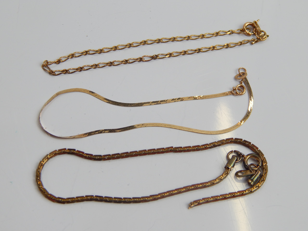 Appraisal: Three various chains to include a fancy link bracelet a