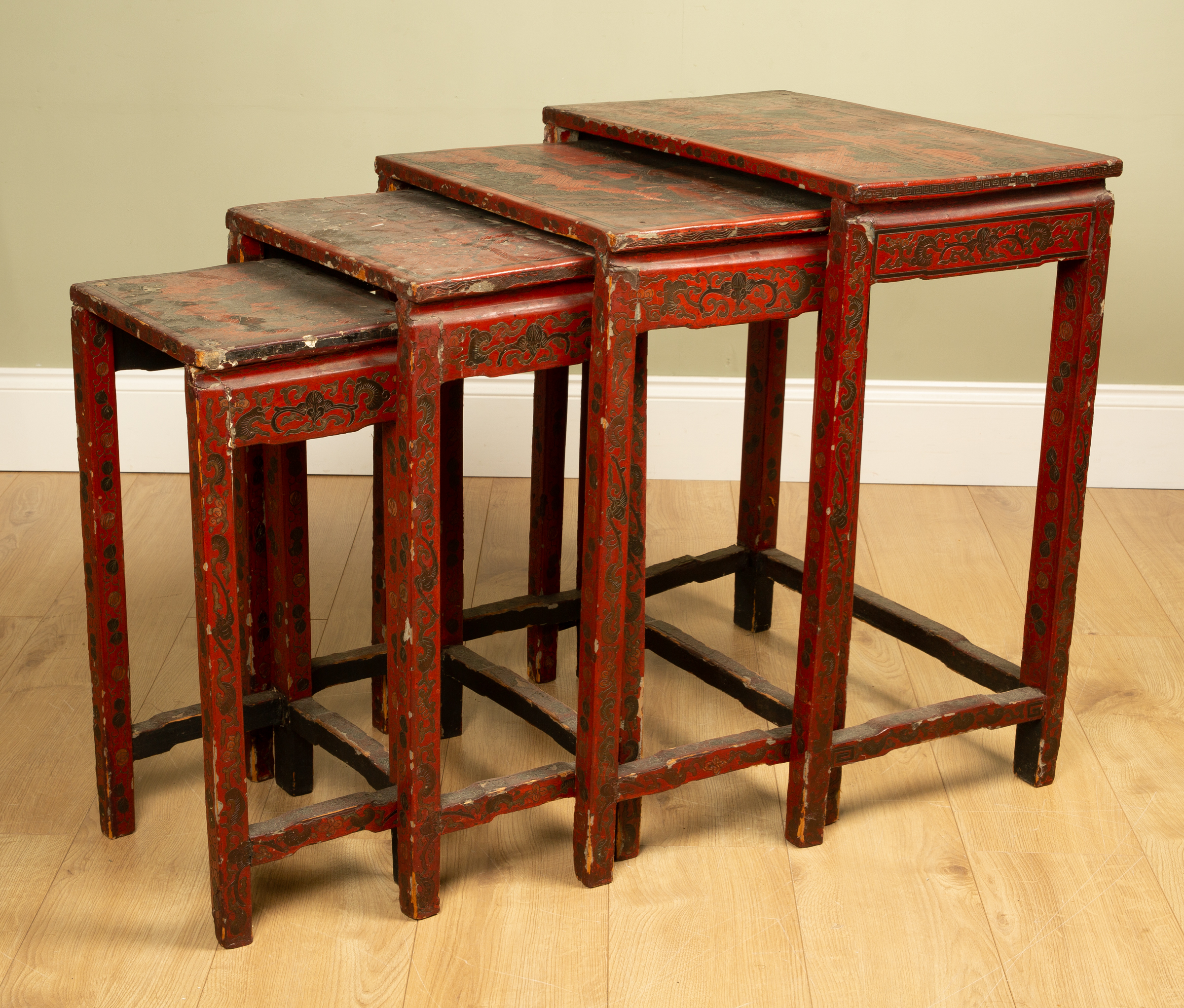 Appraisal: A nest of four chinoiserie-style red lacquered occasional tables the