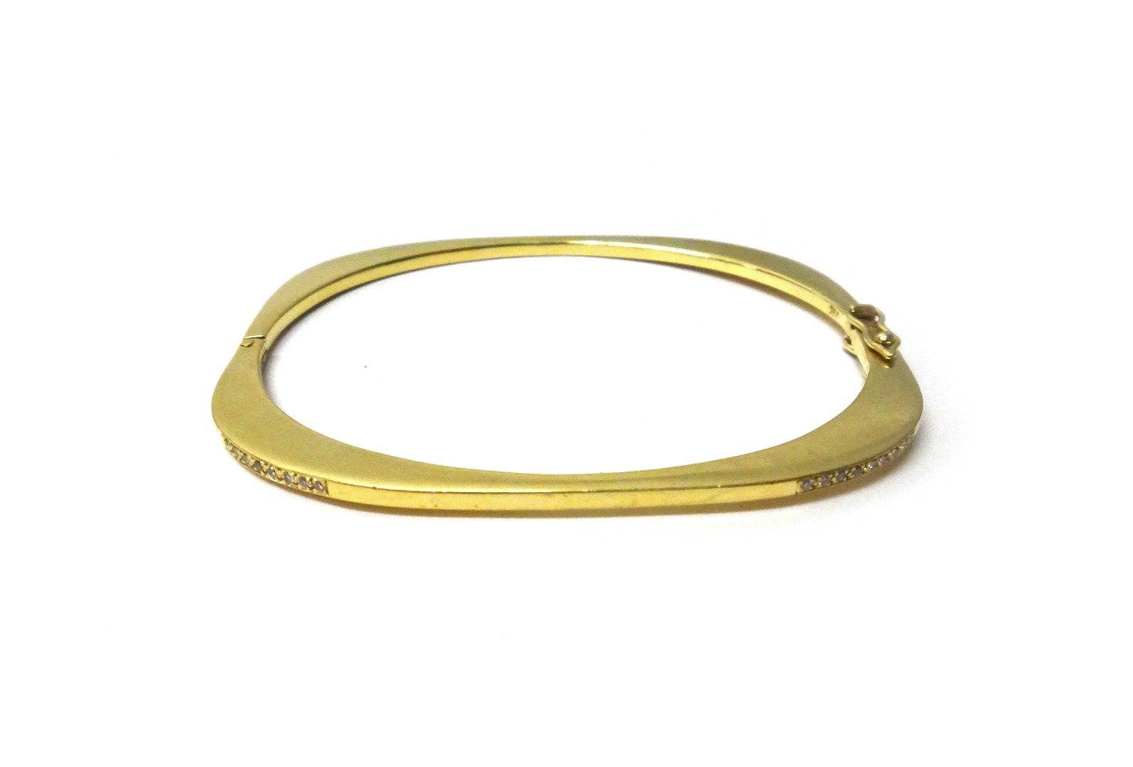 Appraisal: A gold and diamond set hinged bangle the two front