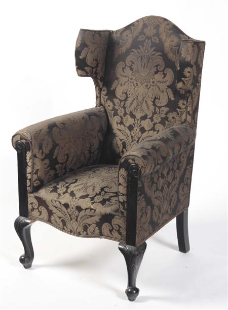 Appraisal: An Edwardian damask wing arm chair the arched top-rail over