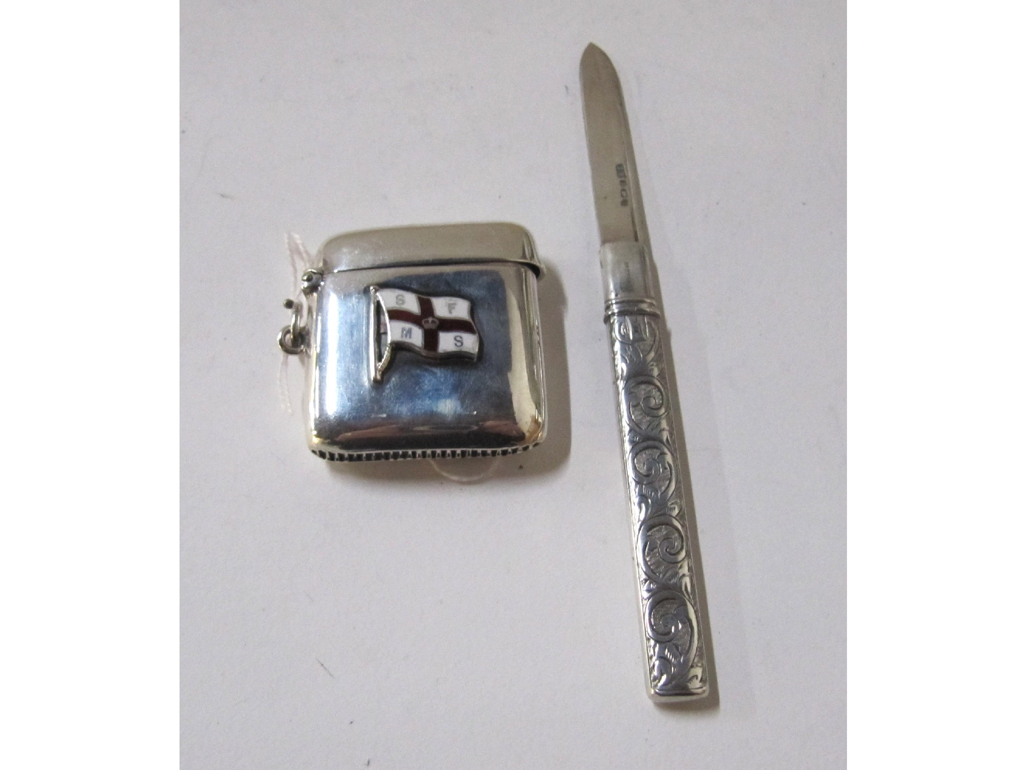 Appraisal: A lot comprising a silver vesta with enamel flag mount