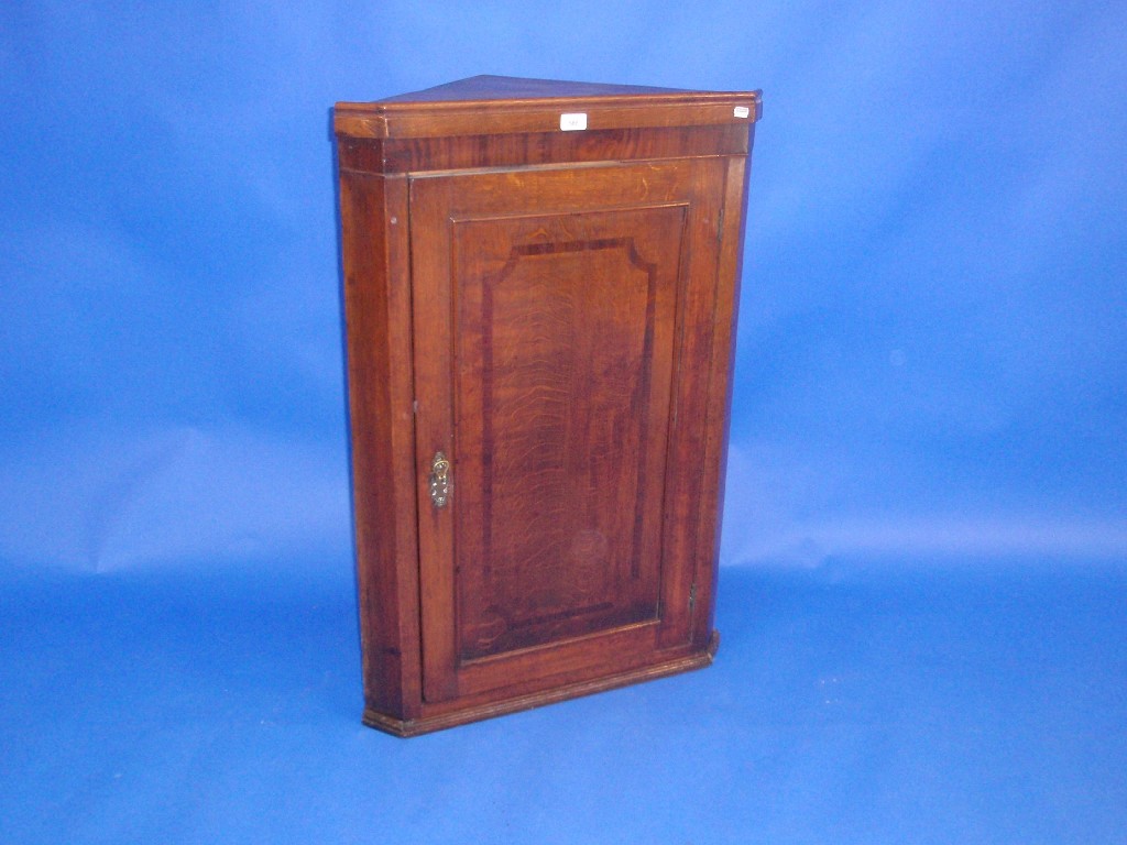 Appraisal: A George III oak hanging corner cupboard with single door