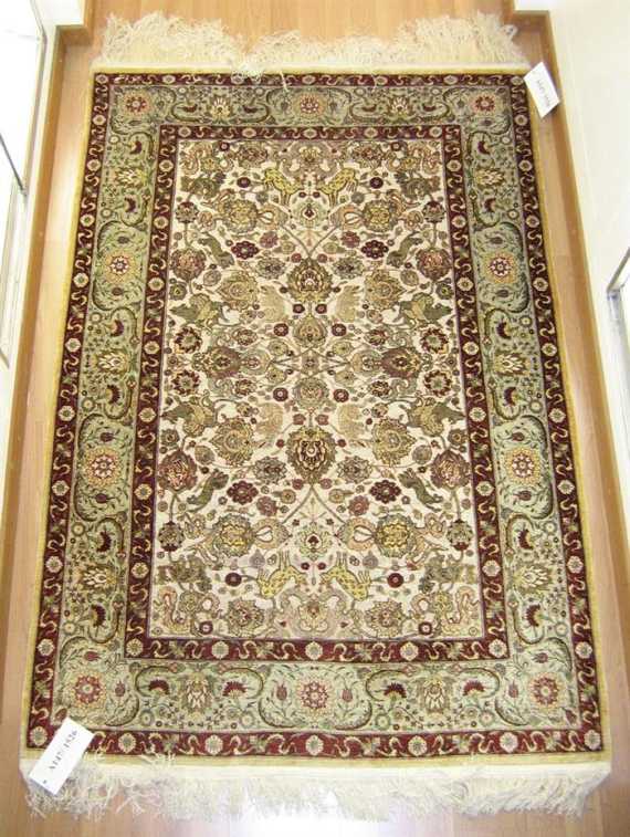 Appraisal: HEREKE silk Beige central field with metal-thread patterned with animals