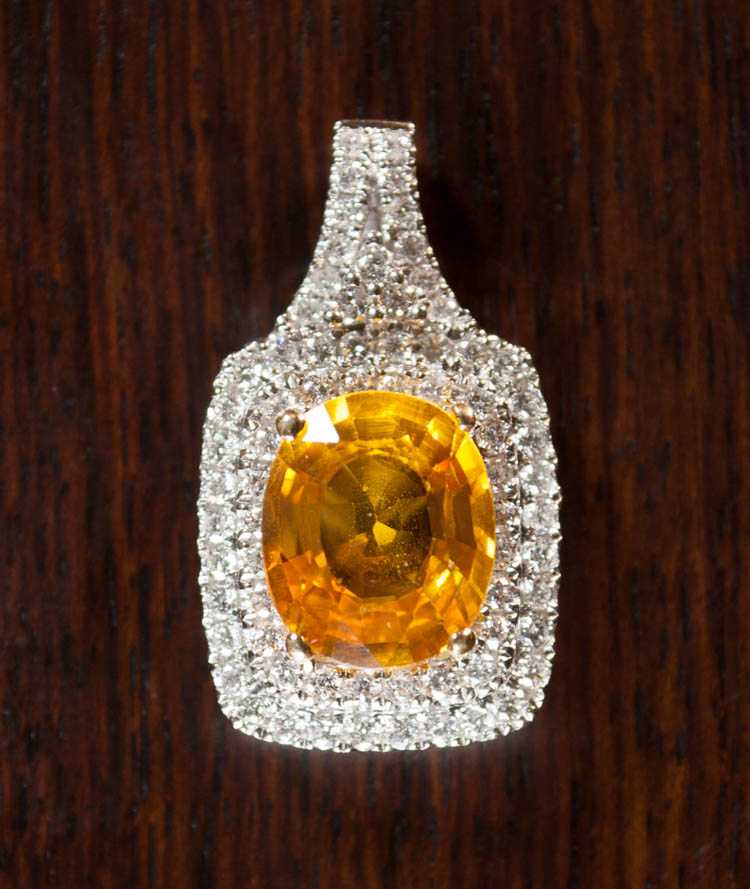 Appraisal: ORANGE SAPPHIRE AND DIAMOND PENDANT k white gold with two