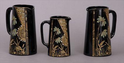 Appraisal: SET OF THREE AESTHETIC MOVEMENT POTTERY PITCHERS Each tapering body