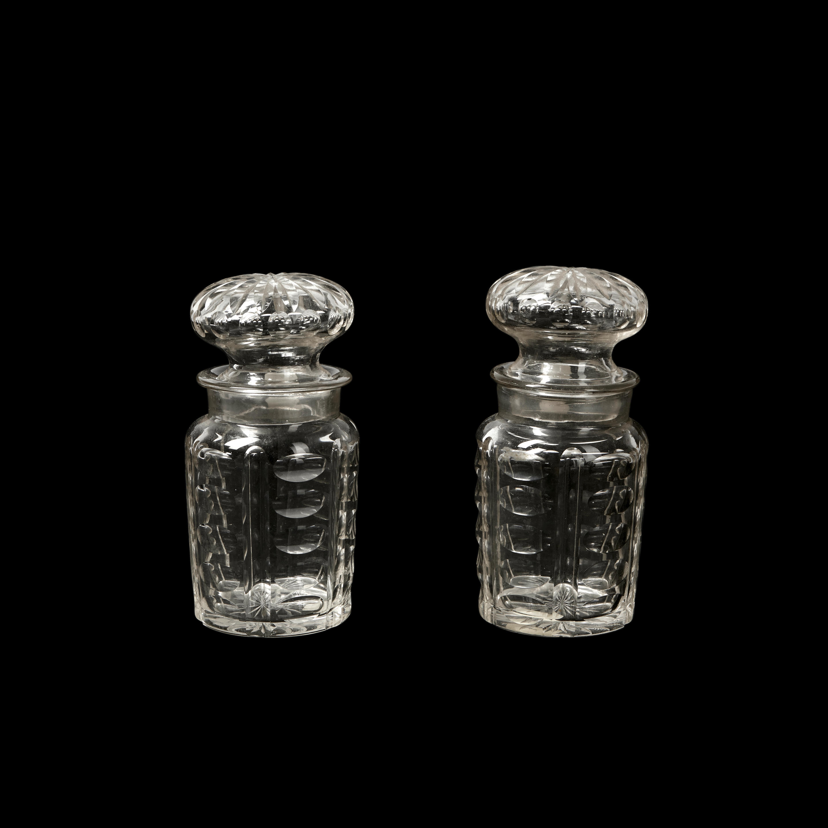 Appraisal: Two Colorless Blown and Wheel-Cut Lidded Glass Jars ht to