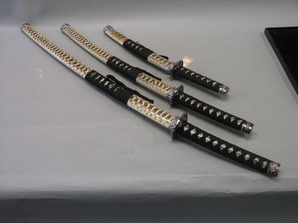 Appraisal: A graduated set of three replica Samurai swords each within