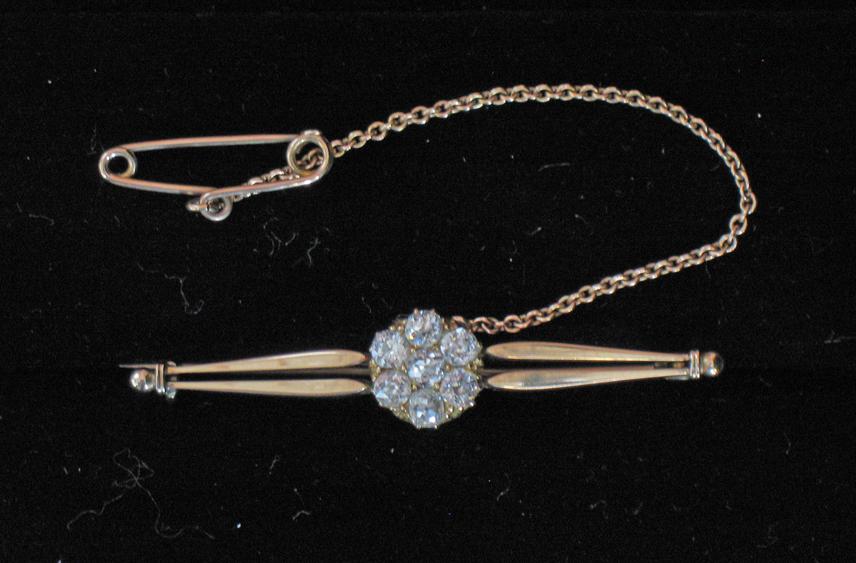 Appraisal: A DIAMOND CLUSTER BAR BROOCH the central flowerhead design formed