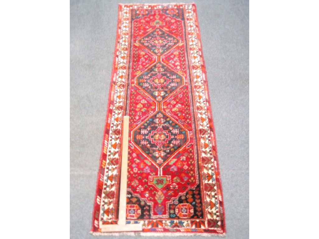 Appraisal: A red ground tri-medallion runner cm x cm