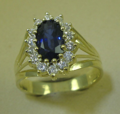 Appraisal: SAPPHIRE DIAMOND AND FOURTEEN KARAT GOLD RING centering an oval-cut