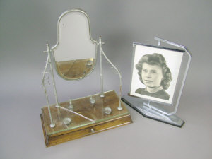 Appraisal: A walnut and silvered metal makeup mirror and stand with