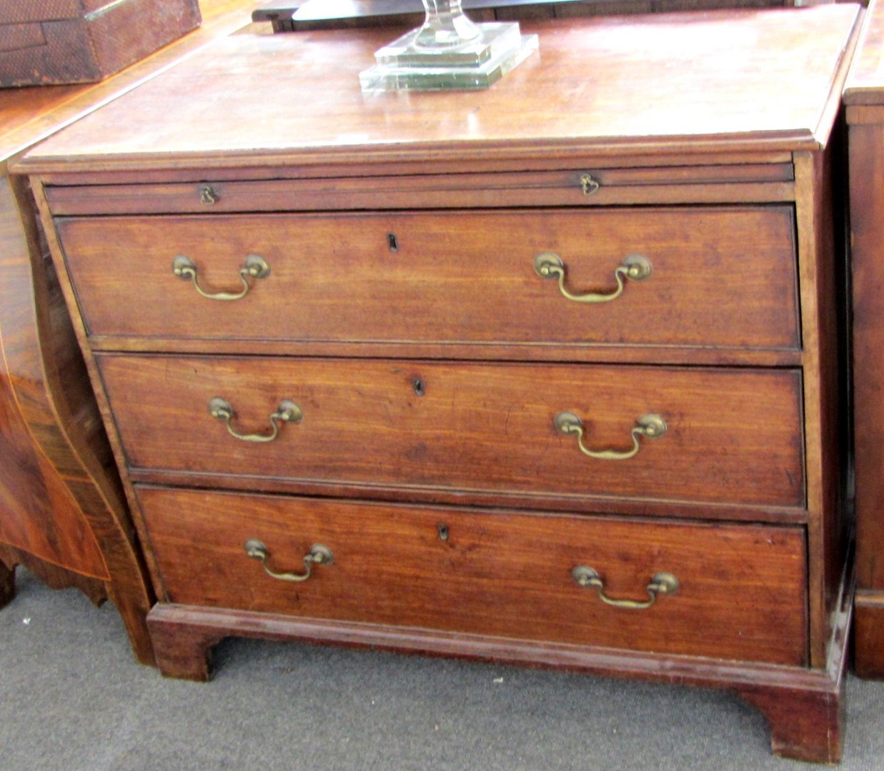 Appraisal: A small George III mahogany chest with brushing slide over